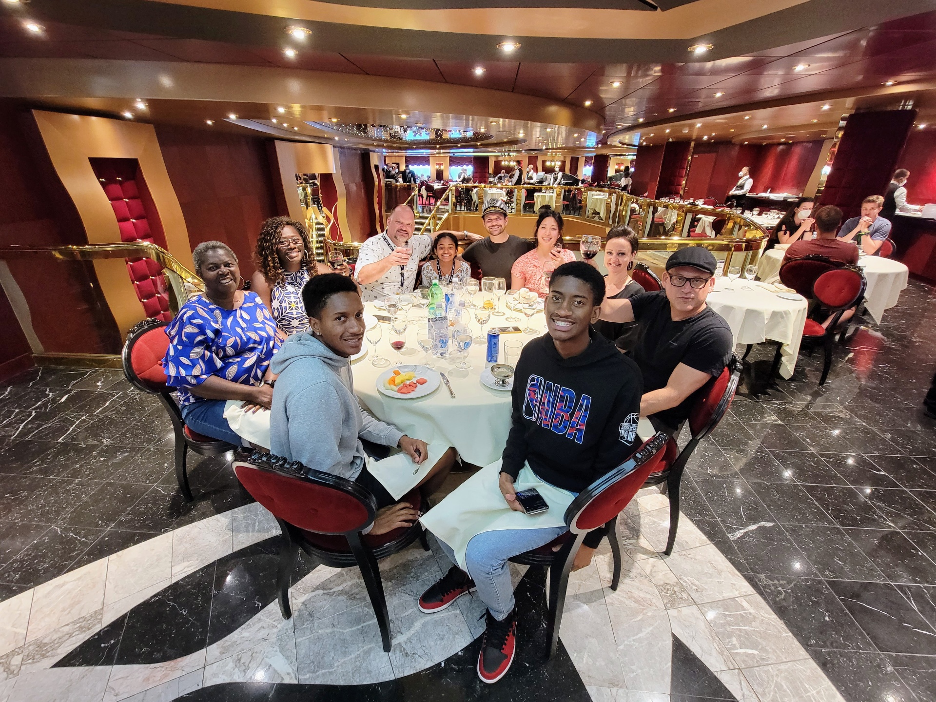 A large group enjoying a formal dinner together on a cruise ship — group travel logistics that advisors handle seamlessly