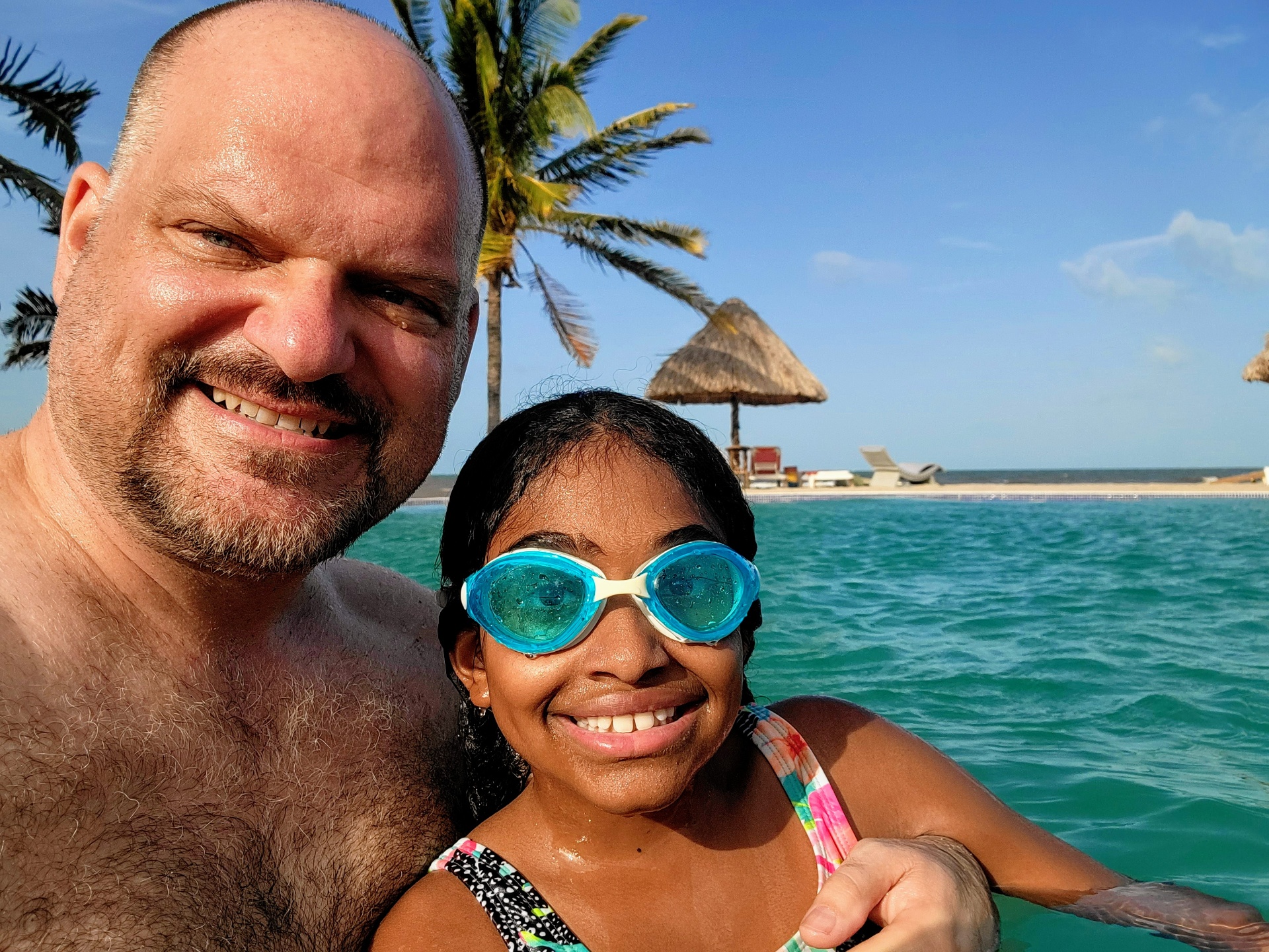 Tony and his daughter having fun in a pool during a family vacation — these moments are what travel is about