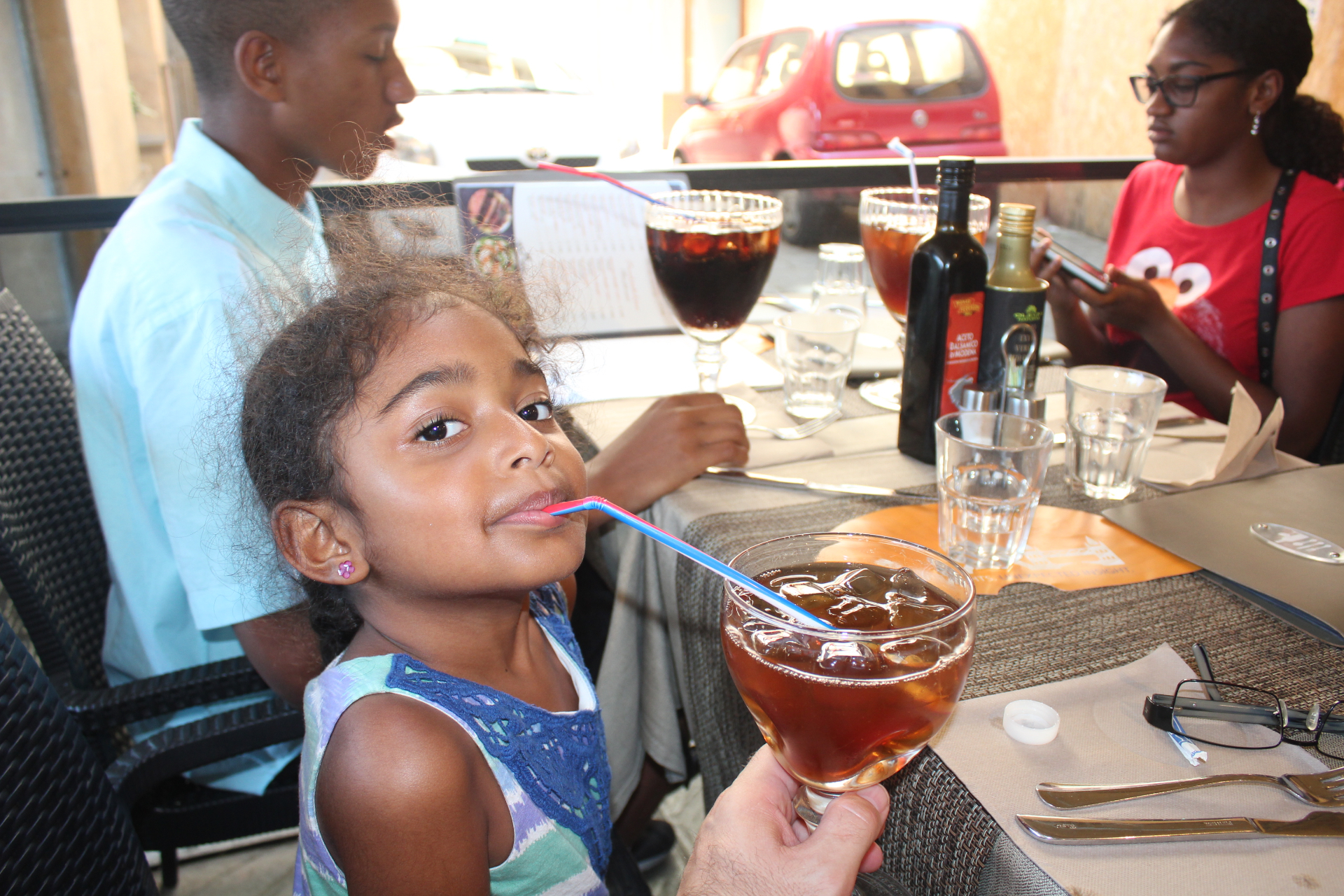Tony's daughter enjoying an Italian drink at an outdoor restaurant